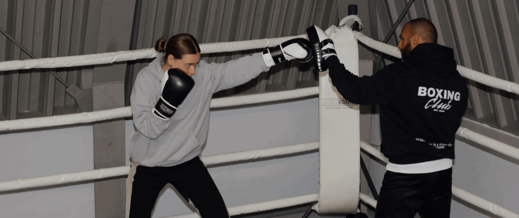 SECRETBOXING Skills Guide. Coach und Boxerin bei der Ausführung des Jab